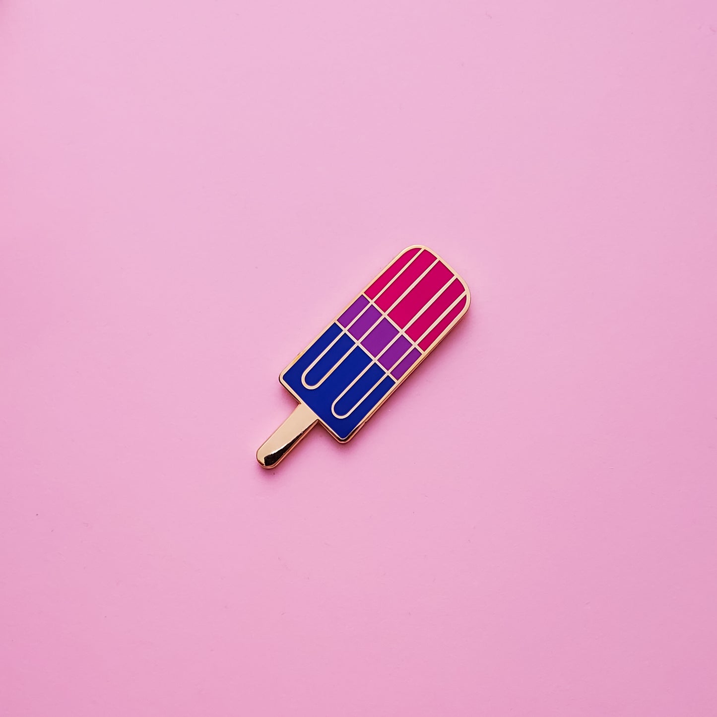 Bisexual Pride Popsicle Pin on a pink background. Pin is has vibrant bisexual pride colours set in a polished nickle metal. Bisexual pride pin colours are pink, purple and blue.Bisexual Popsicle Pin - LGBTQ Pins Canada | Little Rainbow Paper Co