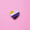 Heart-shaped Nonbinary Pride Pin on a pink background. This Non-binary Pin or Enby pin is has vibrant Non binary pride colours set in a polished nickle metal. Nonbinary pride pin colours are yellow, white, purple and black.Non Binary Heart Pin For Sale - LGBTQ Accessories  | Little Rainbow Paper Co