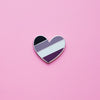 Heart-shaped Asexual Pride Pin on a pink background. This Ace Pin or Asexual pin is has vibrant Ace pride colours set in a polished nickle metal. Ace pride pin colours are black, grey, white and purple. Ace Heart Pin - LGBTQ Pride Pins | Little Rainbow Paper Co