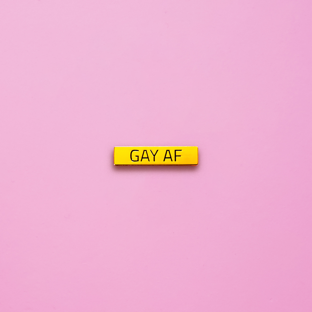 Gold bar Gay AF Pin on a pink background. This LGBTQ pin is set in a polished gold color metal. Gay AF Pin - LGBTQ Pride Pins Canada | Little Rainbow Paper Co