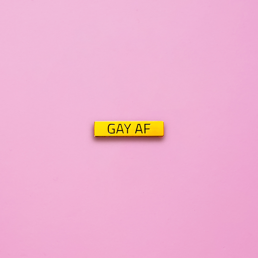 Gold bar Gay AF Pin on a pink background. This LGBTQ pin is set in a polished gold color metal. Gay AF Pin - LGBTQ Pride Pins Canada | Little Rainbow Paper Co