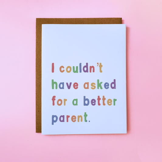 A LGBTQ Parent Card with a kraft envelope on a pink background. This inclusive parent card reads 'I couldn't have asked for a better parent'.